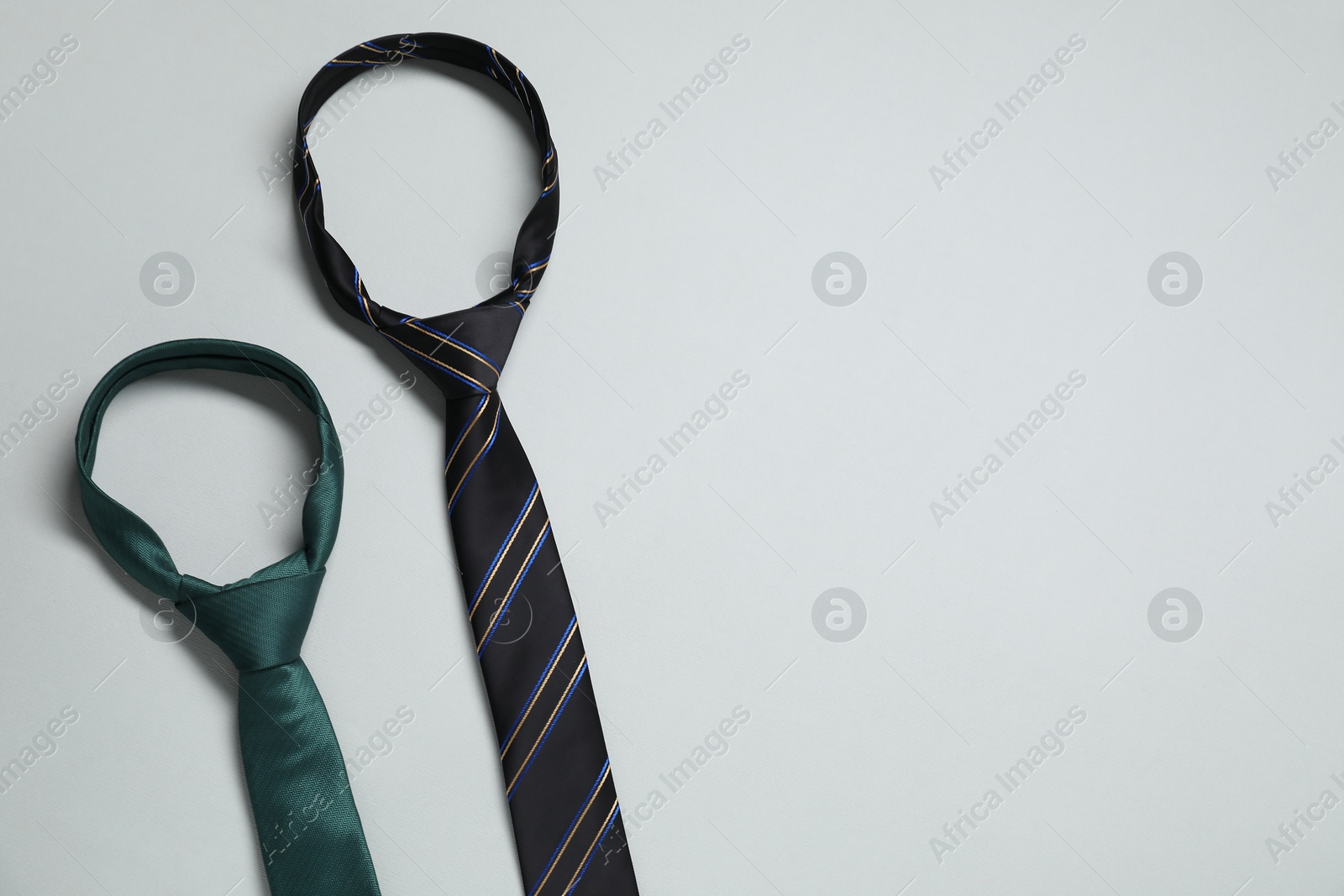 Photo of Neckties on light background, top view. Space for text