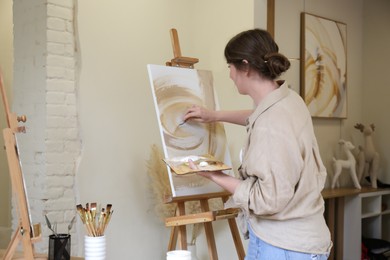 Woman with palette drawing picture in studio