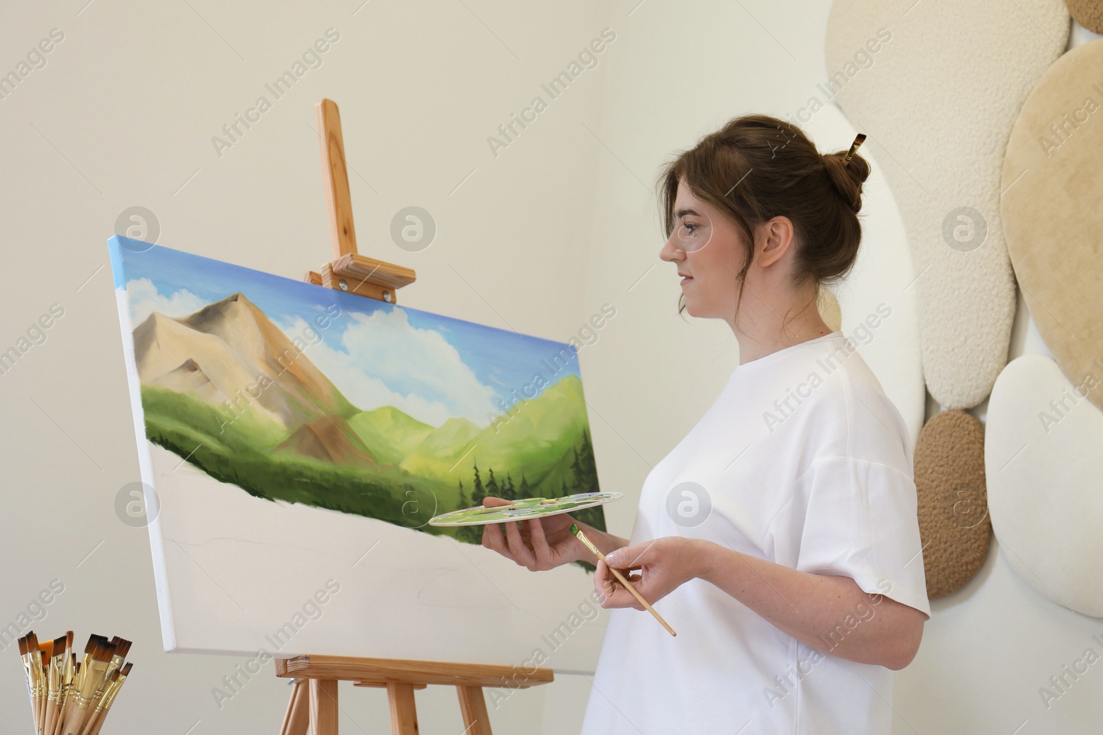 Photo of Woman drawing landscape with brush in studio