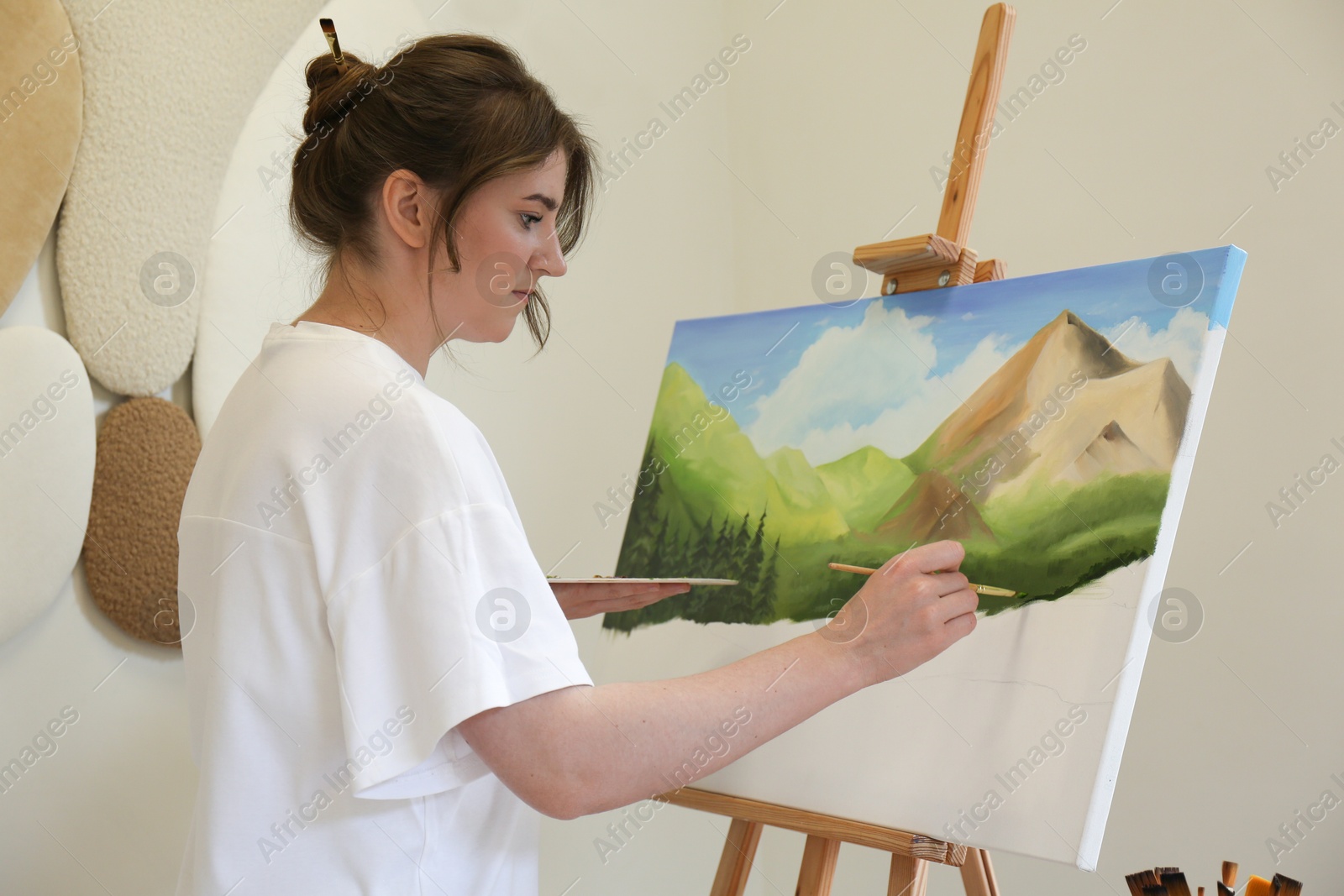 Photo of Woman drawing landscape with brush in studio