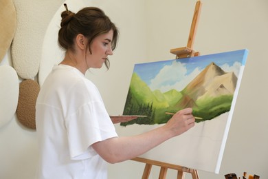 Woman drawing landscape with brush in studio