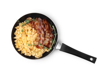 Delicious scrambled eggs with bacon in frying pan isolated on white, top view