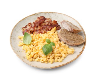 Delicious scrambled eggs with bacon and basil in plate isolated on white