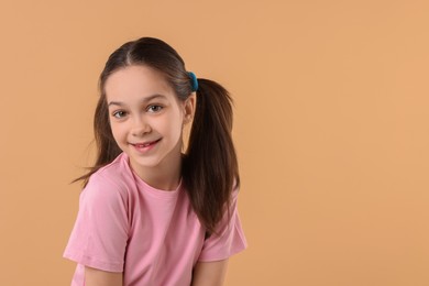 Photo of Portrait of beautiful girl on beige background, space for text