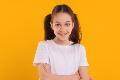 Portrait of happy girl on orange background