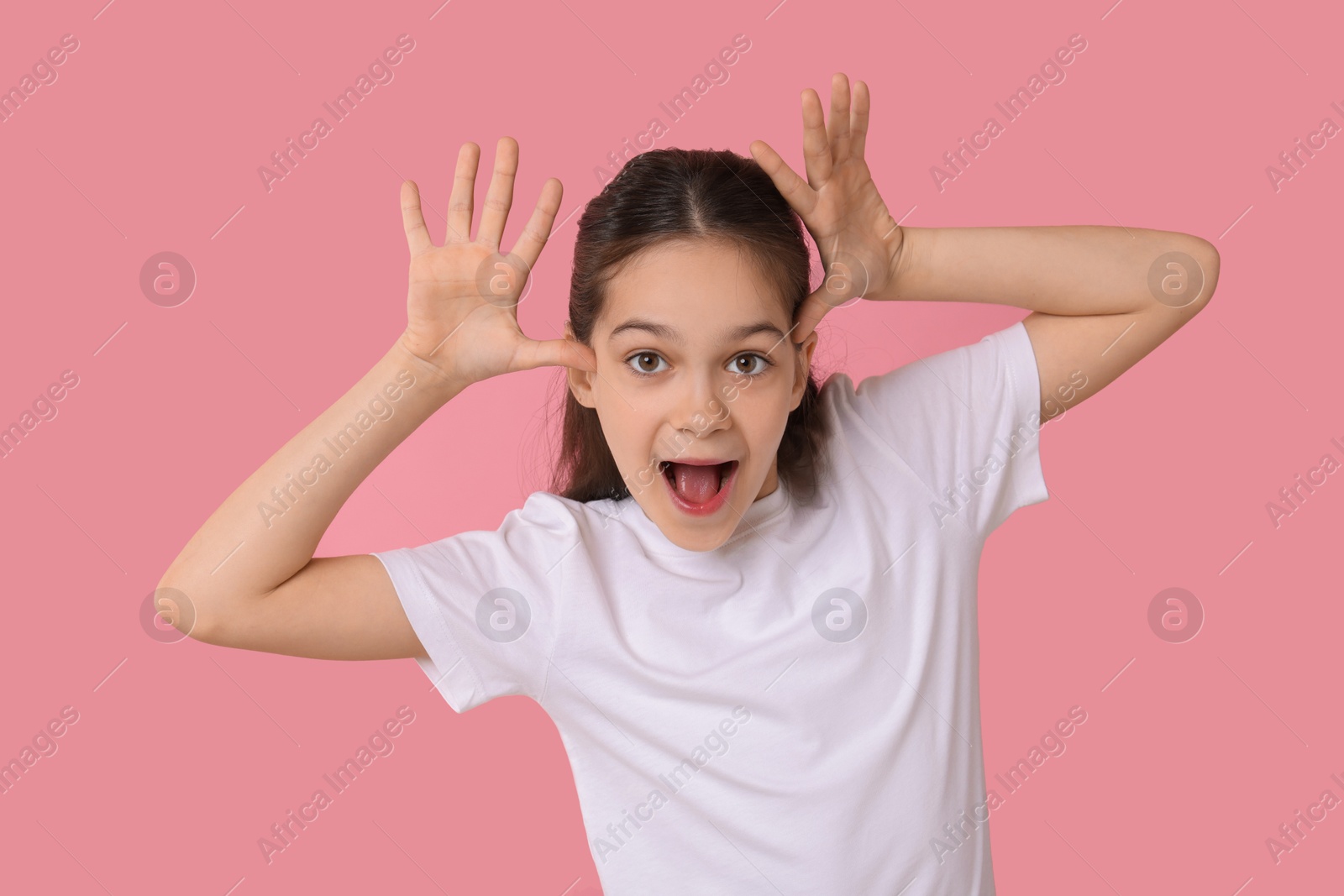 Photo of Portrait of emotional girl on pink background