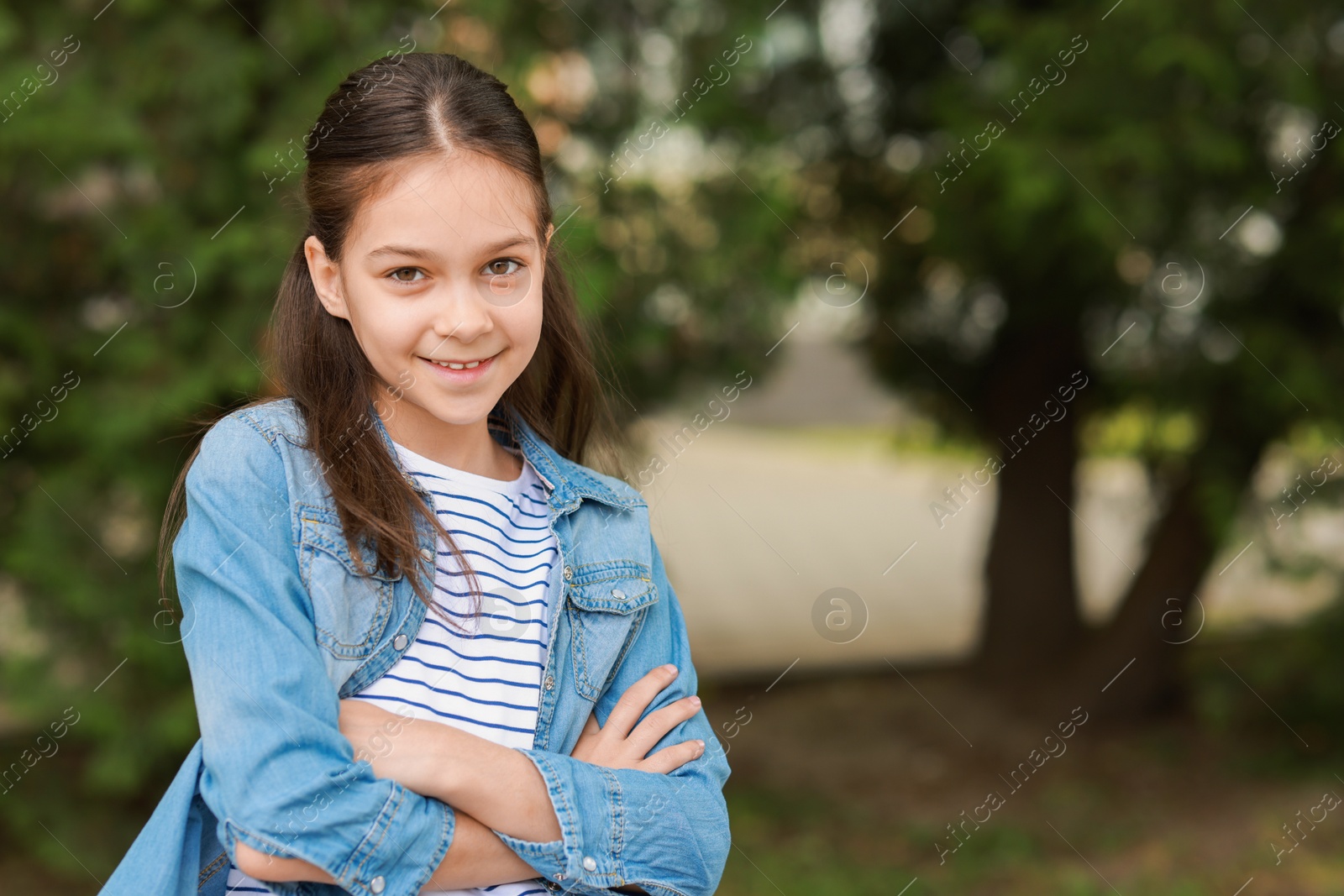 Photo of Portrait of happy little girl outdoors, space for text