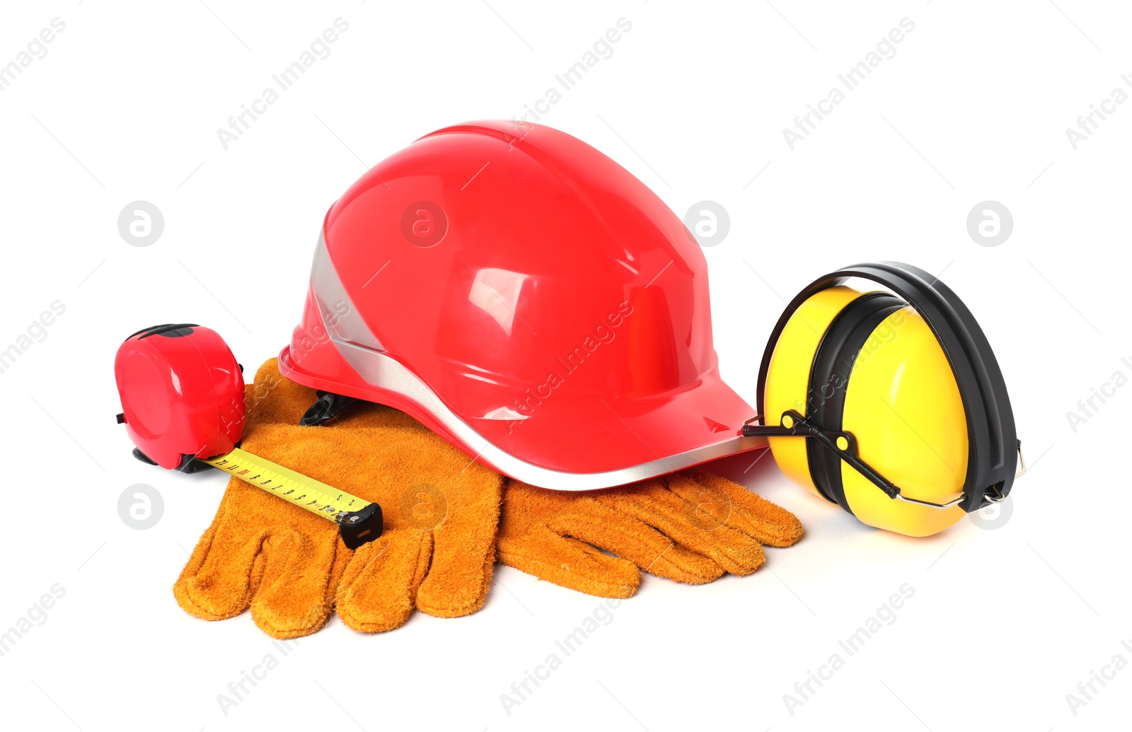 Photo of Orange hard hat, protective gloves, tape measure and earmuffs isolated on white