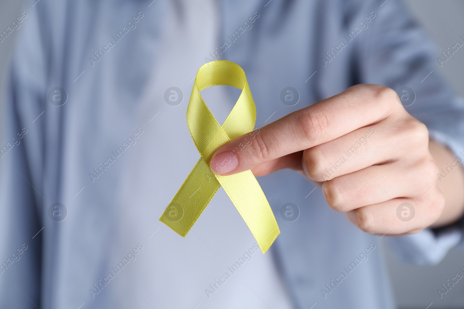 Photo of Woman with yellow awareness ribbon, closeup view