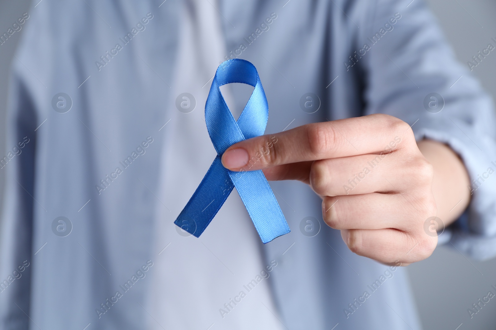 Photo of Woman with blue awareness ribbon, closeup view