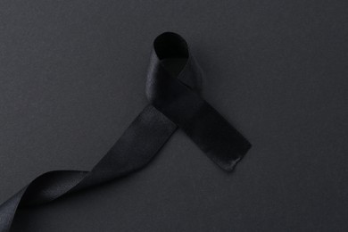 Photo of Black awareness ribbon on color background, top view