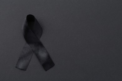 Photo of Black awareness ribbon on color background, top view. Space for text
