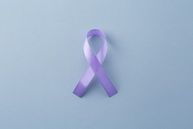 Photo of Violet awareness ribbon on light blue background, top view
