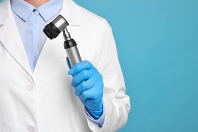 Photo of Dermatologist with dermatoscope on light blue background, closeup. Space for text