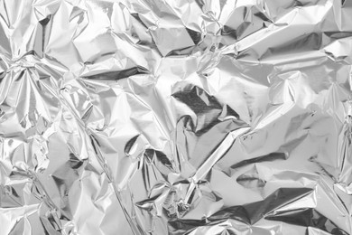 Crumpled silver foil as background, top view