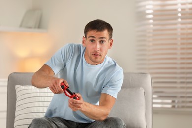 Man playing video games with joystick at home