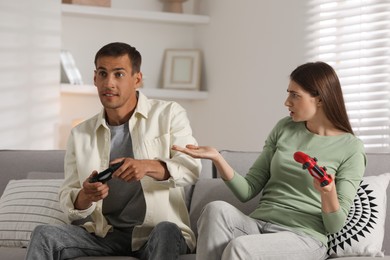 Couple playing video games with controllers at home