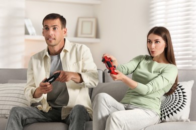 Couple playing video games with controllers at home