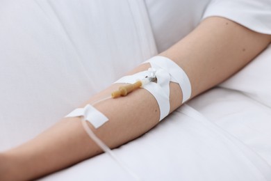 Woman with intravenous drip in hospital bed, closeup