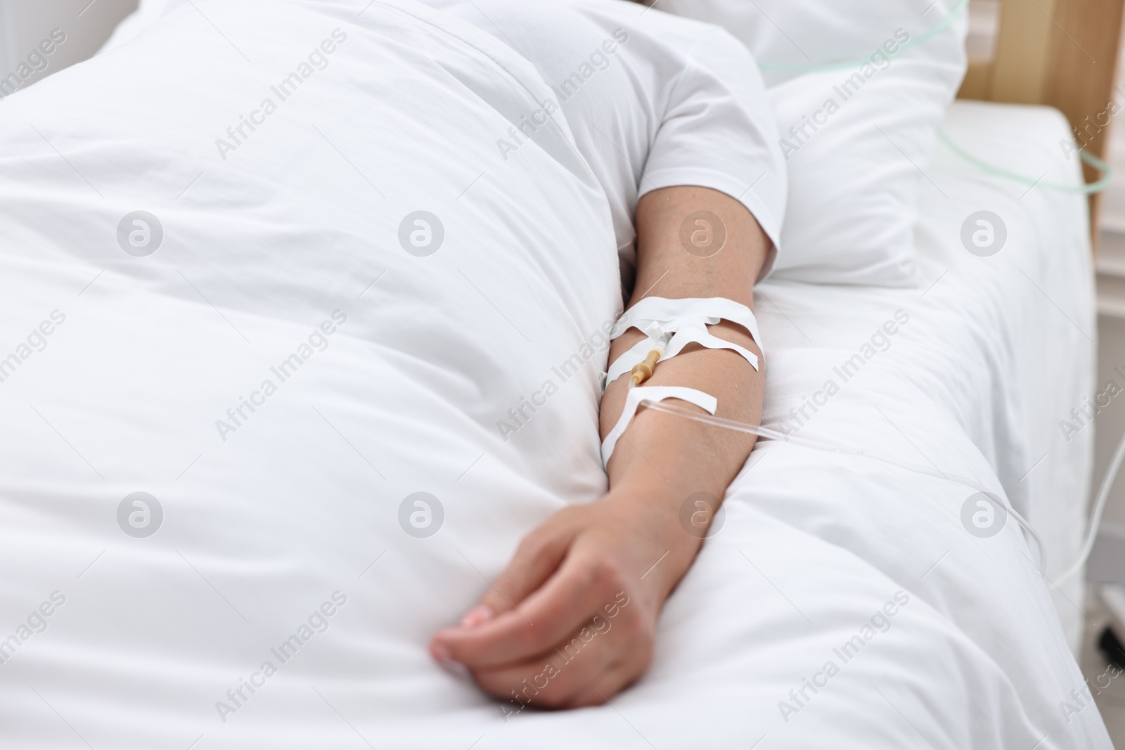 Photo of Woman with intravenous drip in hospital bed, closeup