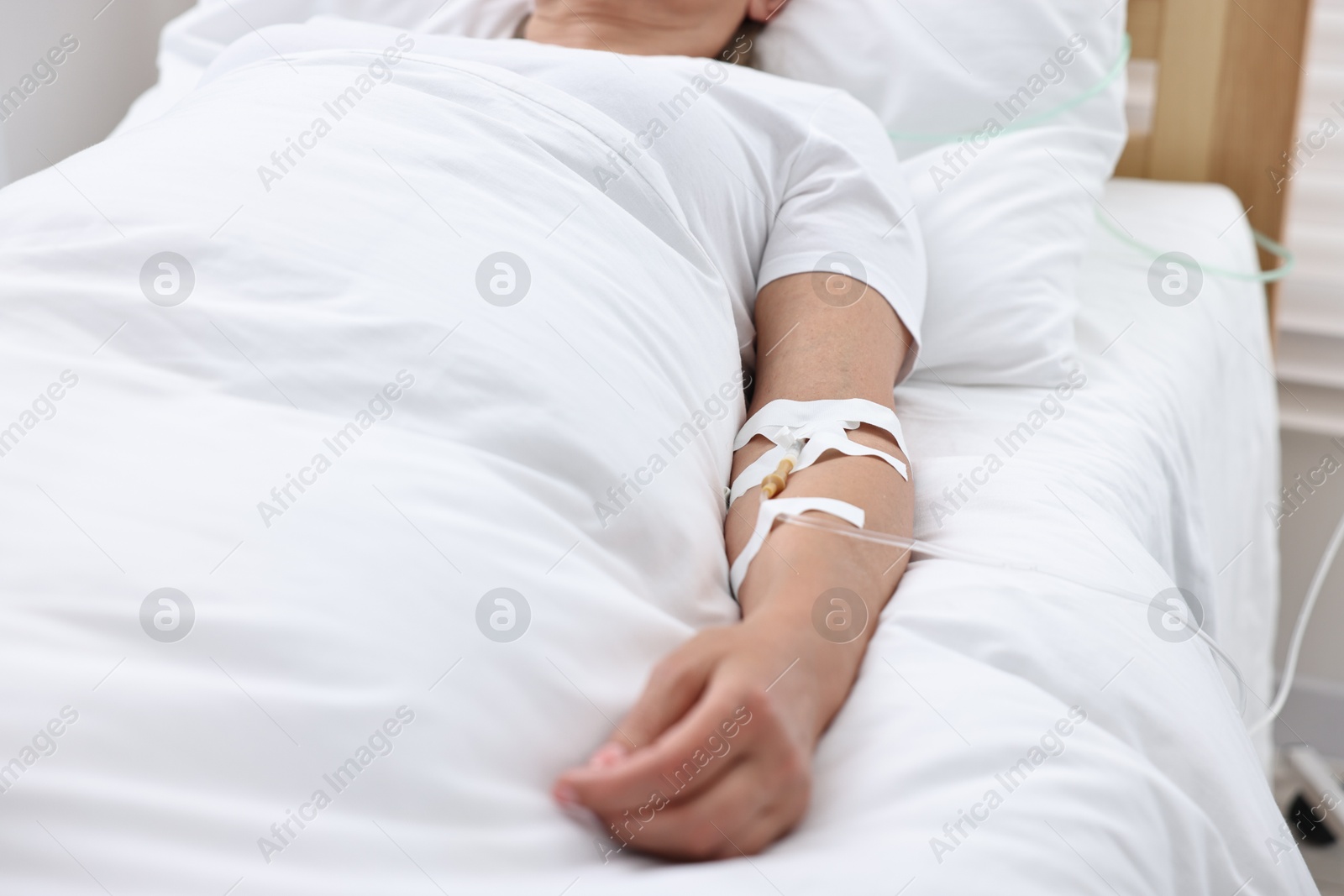 Photo of Coma patient. Woman with intravenous drip in hospital bed, closeup