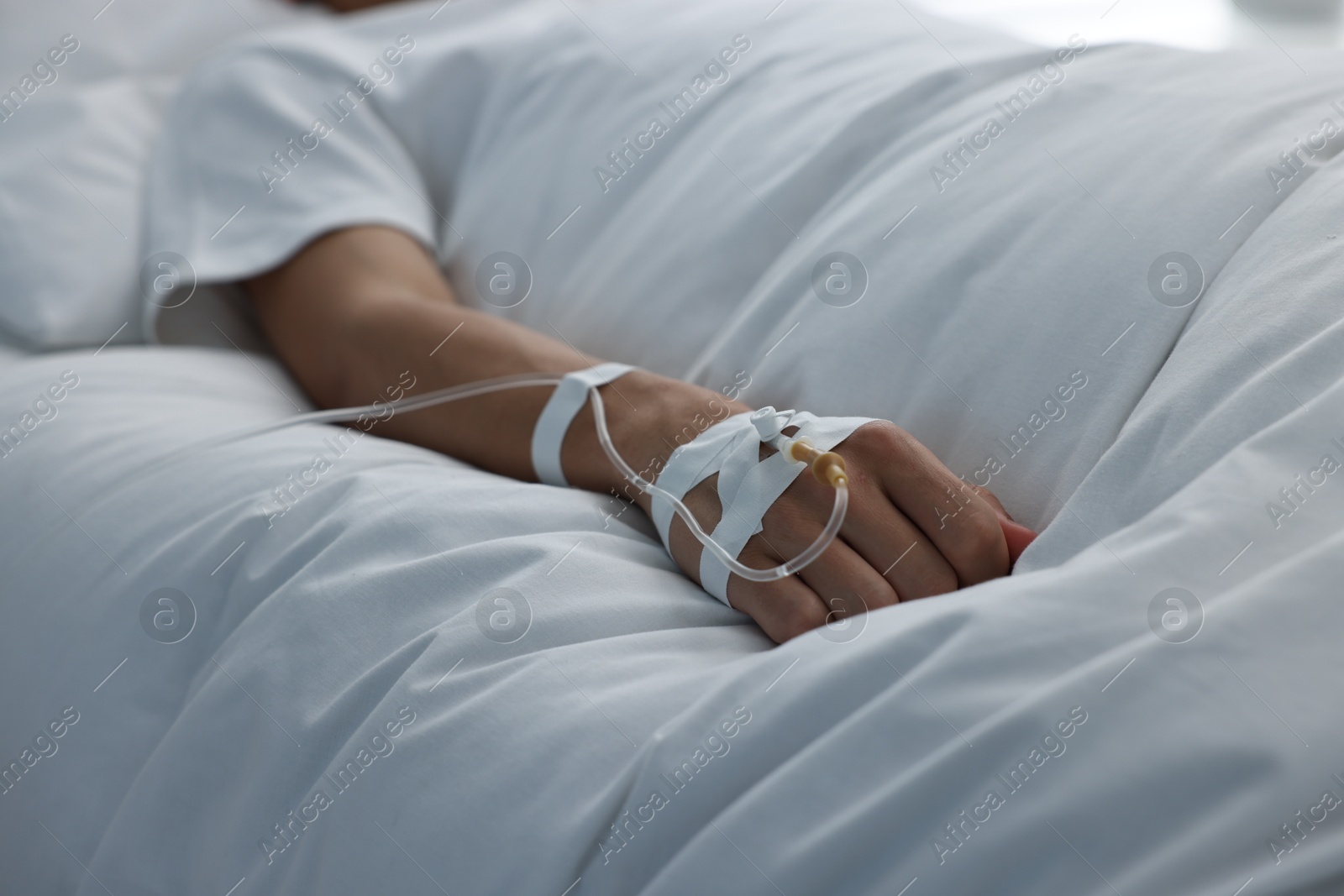 Photo of Woman with intravenous drip in hospital bed, closeup