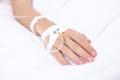 Photo of Woman with intravenous drip in hospital bed, closeup