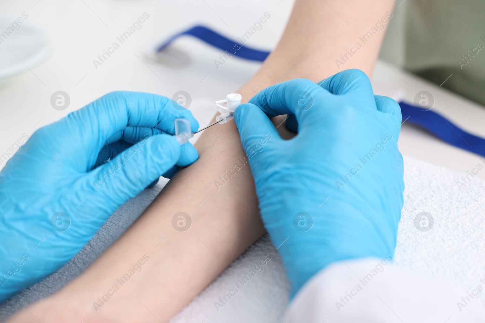 Photo of Nurse inputting catheter for IV drip in patient hand, closeup