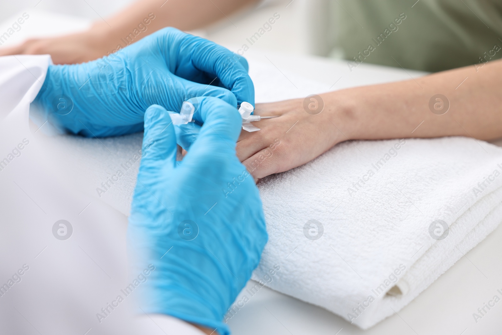 Photo of Nurse inputting catheter for IV drip in patient hand, closeup