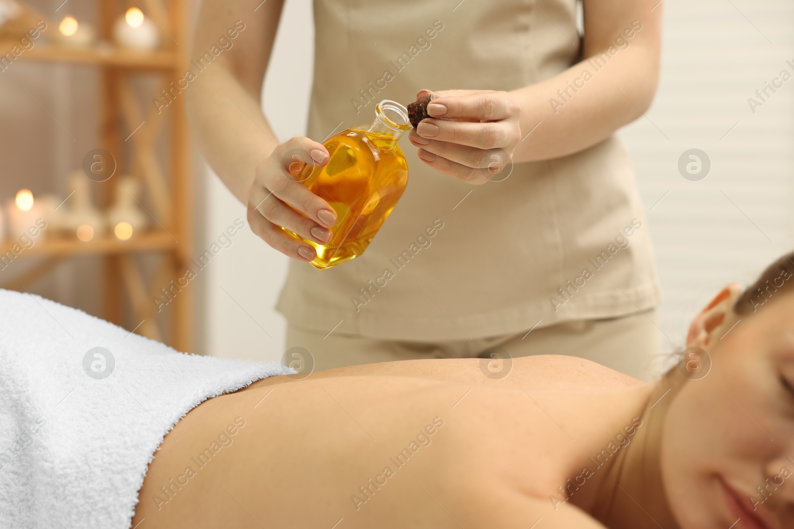 Photo of Aromatherapy. Woman receiving back massage with oil in spa salon, closeup