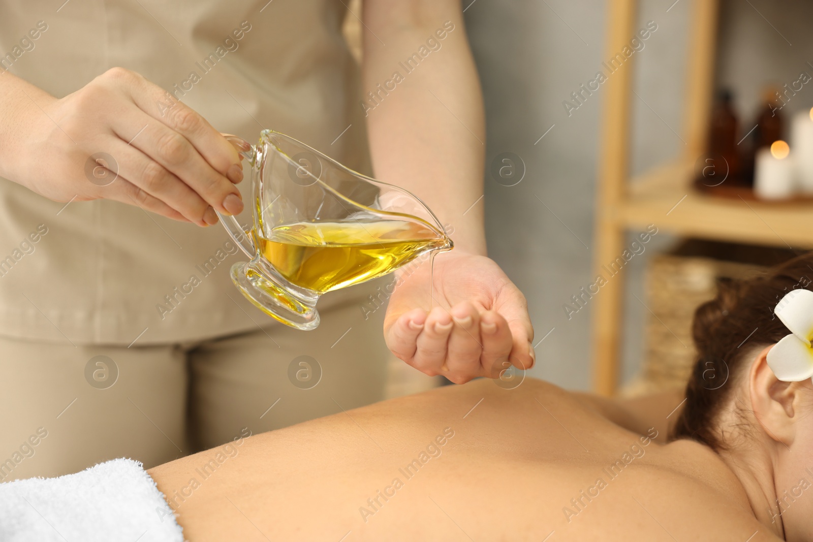 Photo of Aromatherapy. Woman receiving back massage with oil in spa salon, closeup