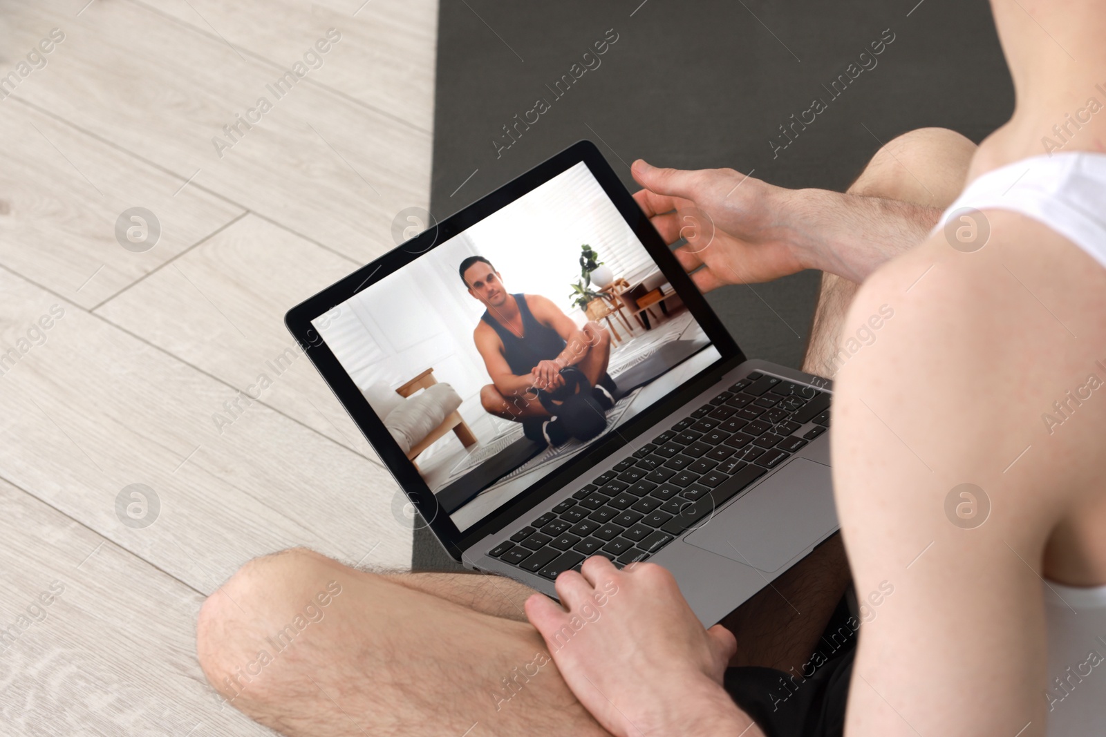 Photo of Online fitness trainer. Man watching tutorial on laptop indoors, closeup