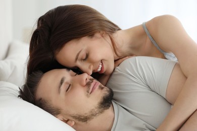 Photo of Lovely couple enjoying each other on bed at home