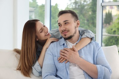 Photo of Happy woman hugging her boyfriend at home