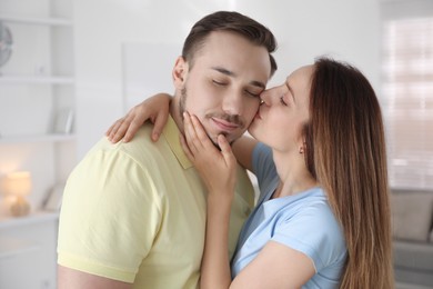 Photo of Woman kissing her boyfriend at home. Strong relationship