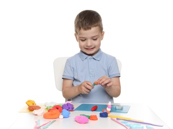 Smiling boy with play dough handiwork at table on white background