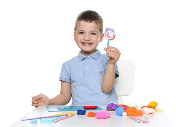 Smiling boy with play dough handiwork at table on white background