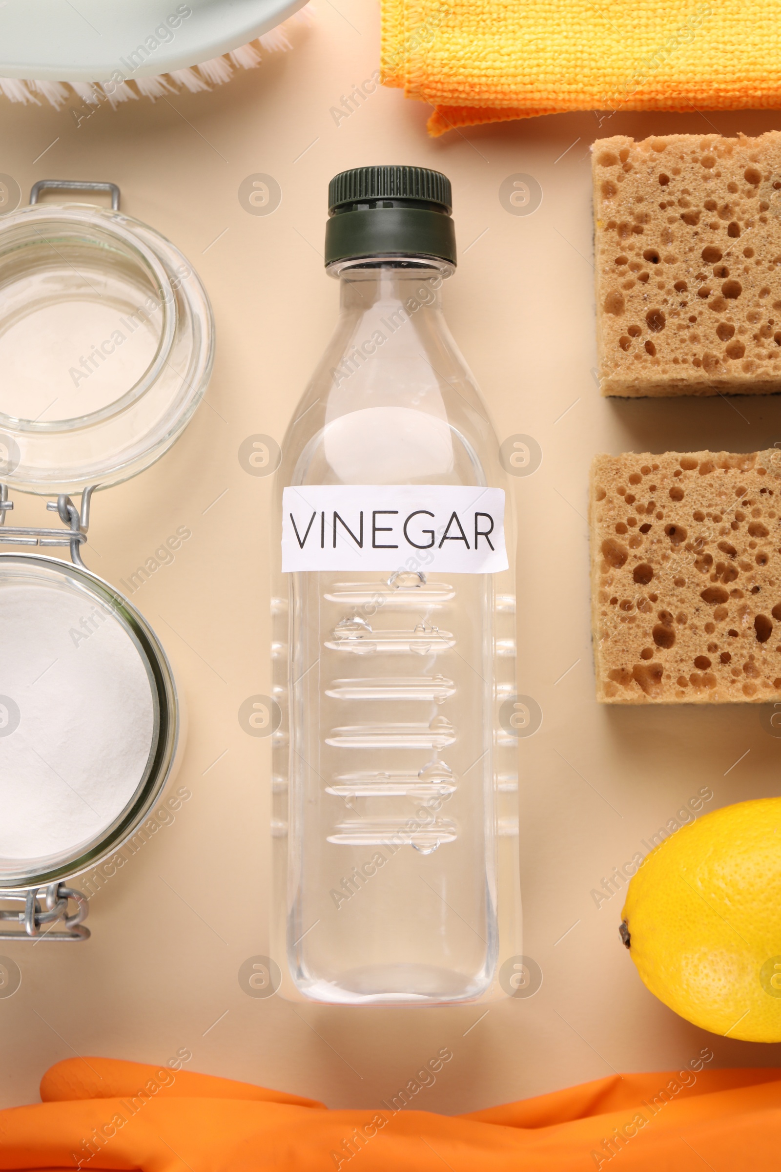 Photo of Eco friendly natural cleaners. Flat lay composition with bottle of vinegar on beige background