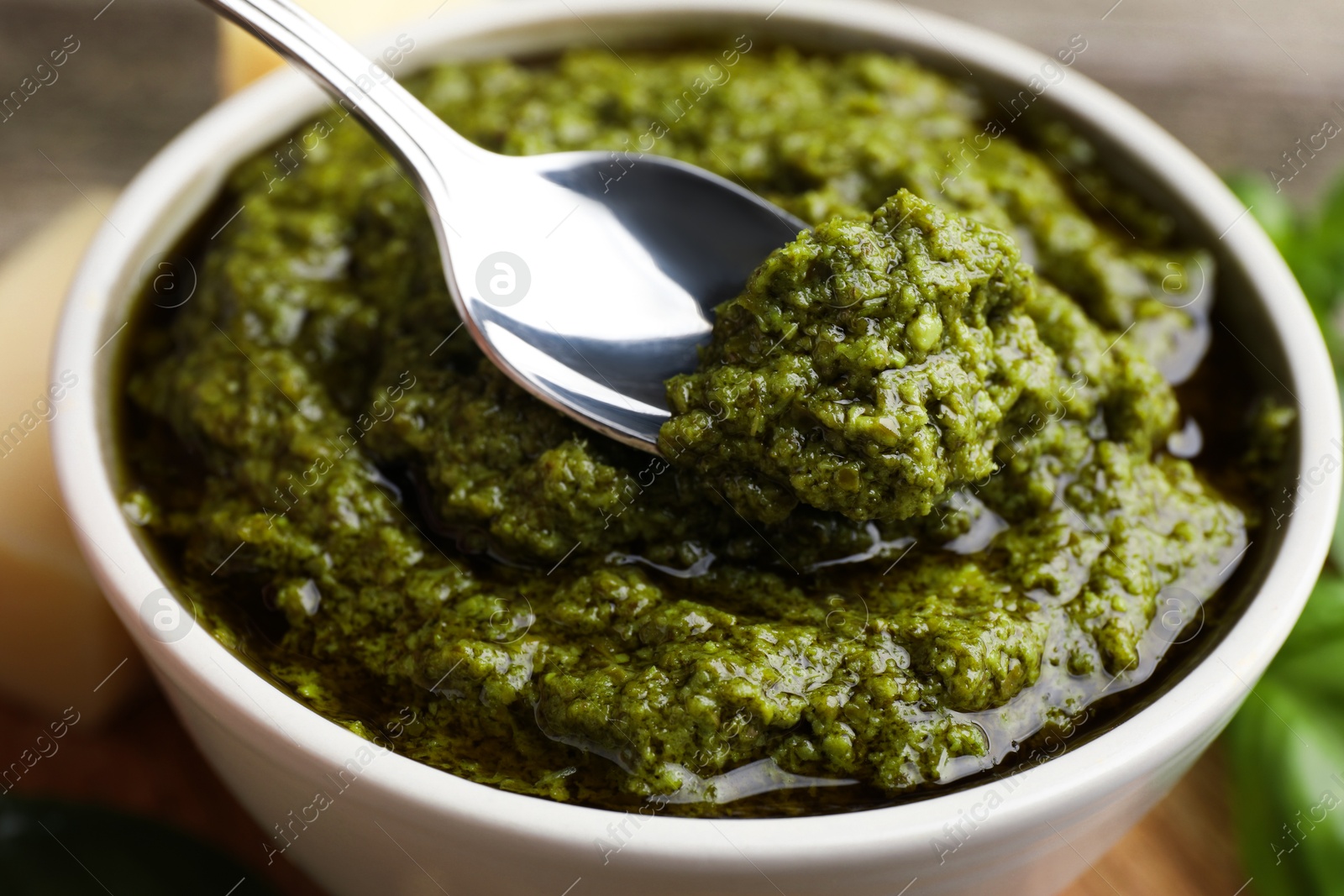 Photo of Taking tasty pesto sauce at table, closeup