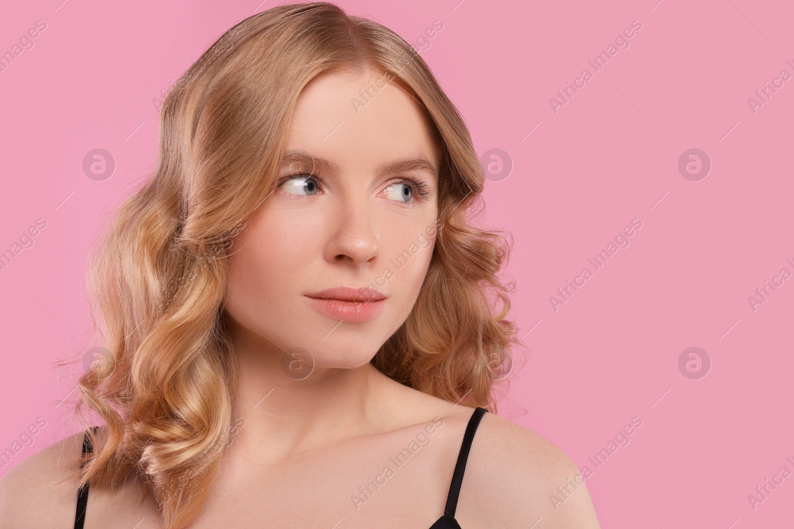 Photo of Portrait of beautiful woman with blonde hair on pink background. Space for text