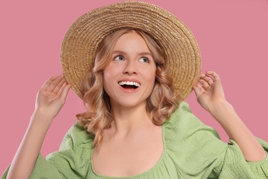 Photo of Portrait of beautiful woman with blonde hair in hat on pink background