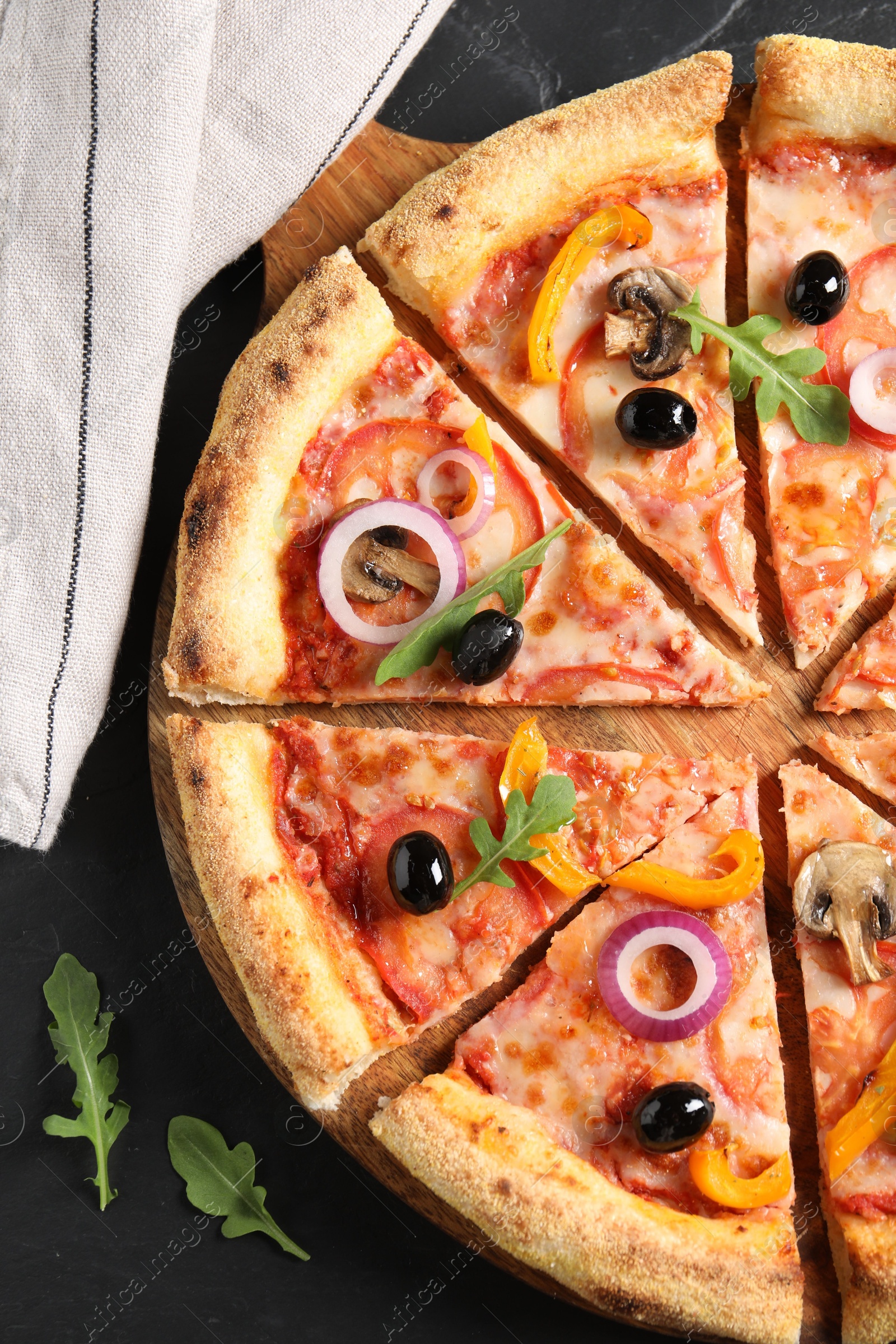 Photo of Cut delicious vegetarian pizza on black table, top view