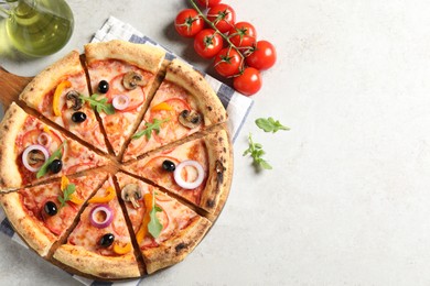 Photo of Cut delicious vegetarian pizza, oil and tomatoes on light table, top view. Space for text