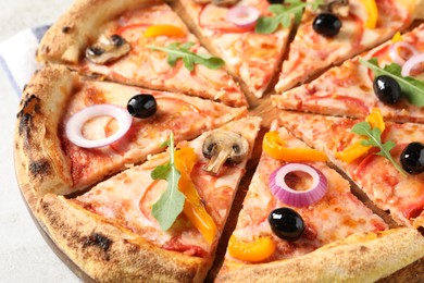 Photo of Cut delicious vegetarian pizza on light table, closeup