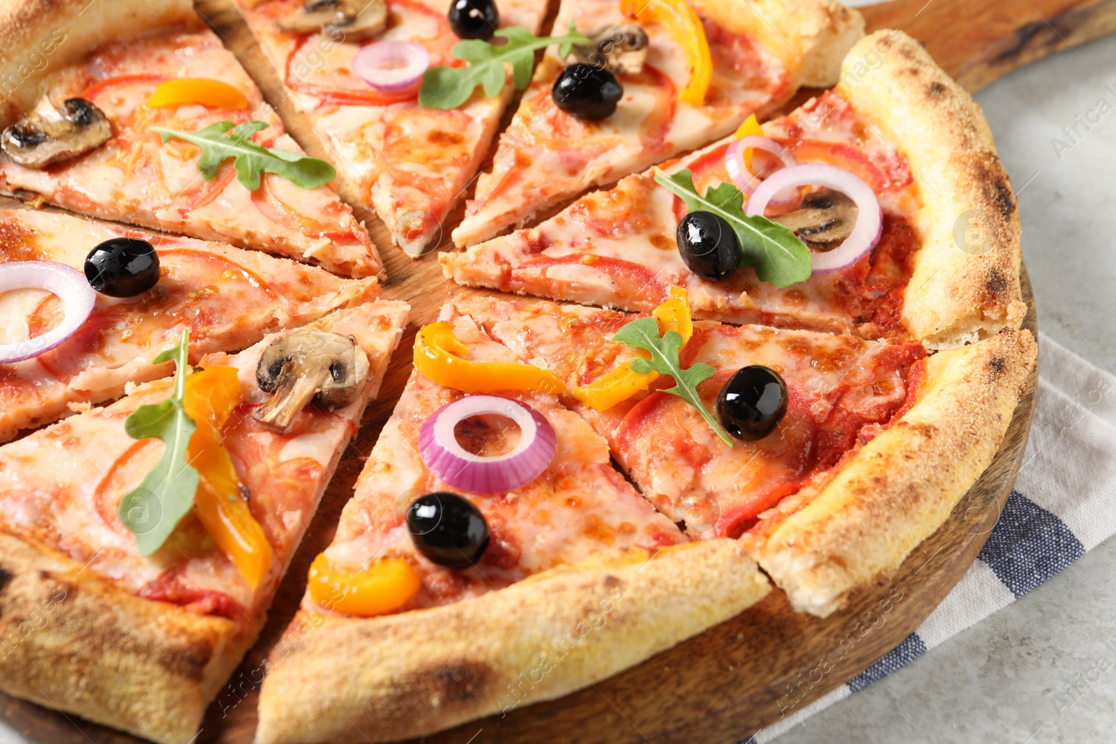 Photo of Cut delicious vegetarian pizza on light table, closeup