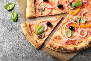 Photo of Cut delicious vegetarian pizza on grey table, closeup