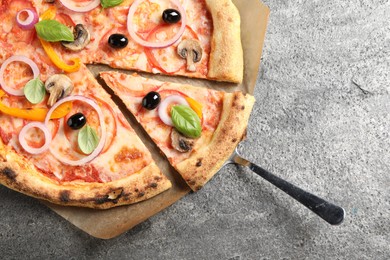 Photo of Cut delicious vegetarian pizza on grey table, closeup