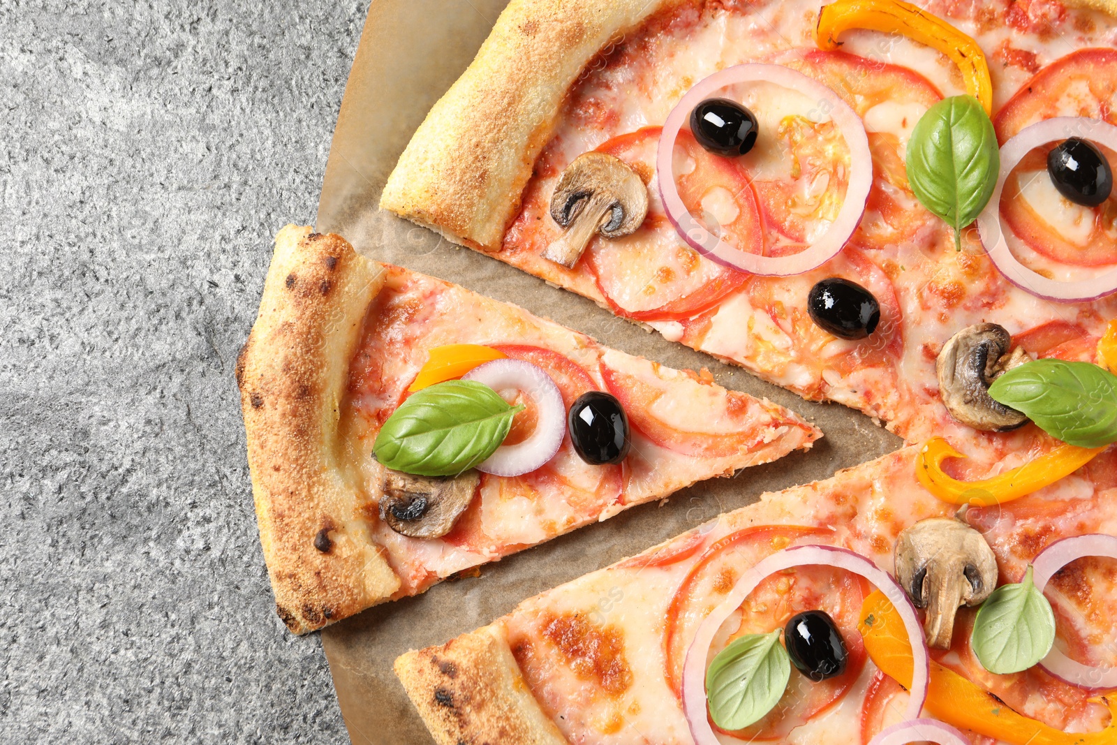 Photo of Cut delicious vegetarian pizza on grey table, closeup