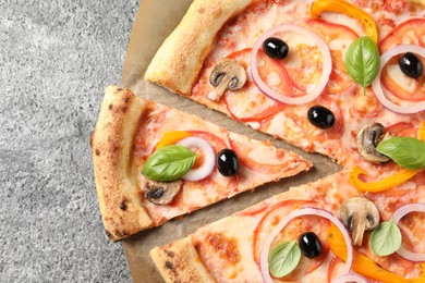 Photo of Cut delicious vegetarian pizza on grey table, closeup