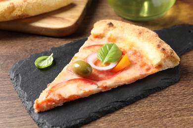 Photo of Slice of delicious vegetarian pizza on wooden table, closeup